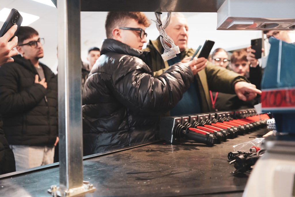 Estudiantes observando y fotografiando componentes electrónicos durante su visita a las instalaciones de RB Componentes.